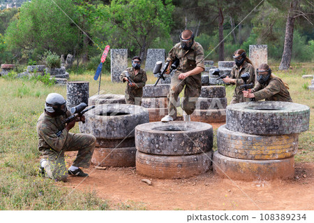 Two active opposing teams with guns playing paintball Two active opposing teams with guns playing paintball 108389234