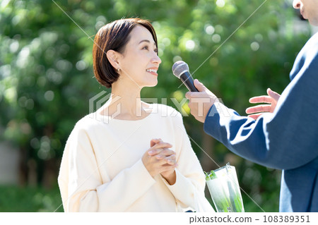 A woman being interviewed on her way home from shopping A woman being interviewed on her way home from shopping 108389351