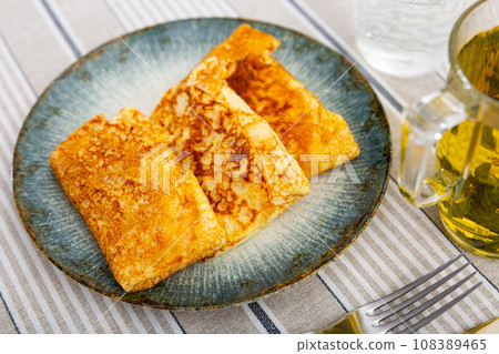 Stuffed sweet thin crepes served with herbal tea for breakfast 108389465