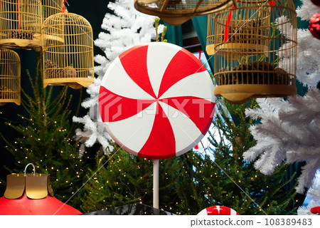 Holiday counter striped lollipop sweet candy. Cold weather, winter market holidays fair, travel resort celebrating. New Year Christmas decorations fluffy spruce tree branch pine 108389483