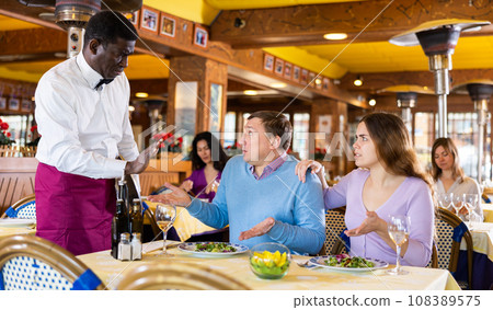 Displeased guests conflicting with waiter Displeased guests conflicting with waiter 108389575