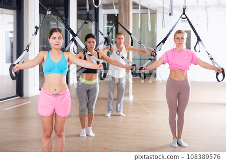 Four people doing pilates exercises with reformer Four people doing pilates exercises with reformer 108389576