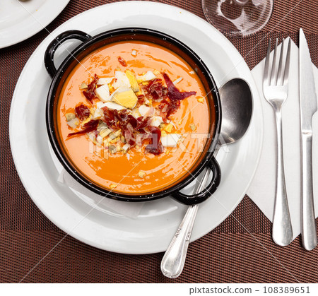 There is large portion of soup salmorejo cordoba decorated with hill of ham and egg chips There is large portion of soup salmorejo cordoba decorated with hill of ham and egg chips 108389651