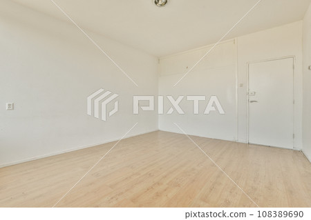 an empty room with white walls and wood flooring the room is clean and ready to be used for storage 108389690