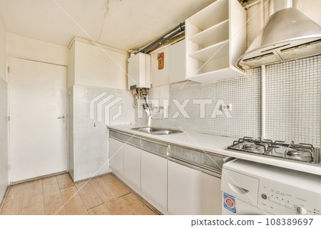 a small kitchen with white cabinets and appliances on the counter top in front of the washer, dishwasher and dryer 108389697