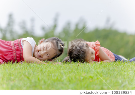 小學生在公園的草地上玩耍 小學生在公園的草地上玩耍 108389824