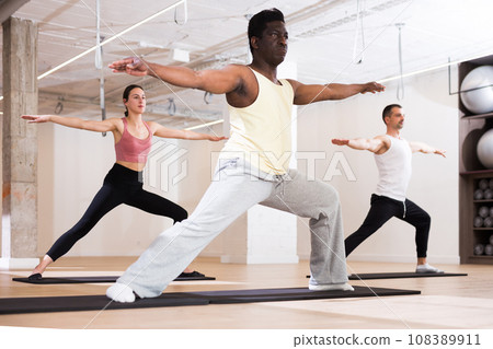 Man practicing pilates exercises at group class Man practicing pilates exercises at group class 108389911