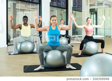 Sporty girl doing group workout with fitness ball 108389946