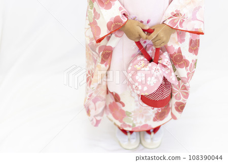 A girl wearing a Shichi-Go-San kimono and holding a drawstring bag (3 years old, Japanese, faceless) A girl wearing a Shichi-Go-San kimono and holding a drawstring bag (3 years old, Japanese, faceless) 108390044