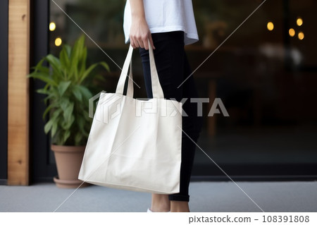 Model hold blank white fabric mockup bag for save environment on street fashion Model hold blank white fabric mockup bag for save environment on street fashion 108391808