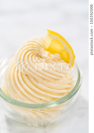 Swirl lemon buttercream frosting in a small glass bowl. 108392006