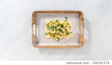 Flat lay. Spreading unsalted butter at room temperature to prepare a vegetarian party butter board for a party. Flat lay. Spreading unsalted butter at room temperature to prepare a vegetarian party butter board for a party. 108392178