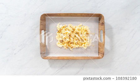 Flat lay. Spreading unsalted butter at room temperature to prepare a vegetarian party butter board for a party. Flat lay. Spreading unsalted butter at room temperature to prepare a vegetarian party butter board for a party. 108392180