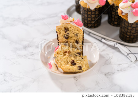Freshly baked mini Easter bread kulich with lemon glaze, decorated with sprinkles and meringue bird-shaped cookies. Freshly baked mini Easter bread kulich with lemon glaze, decorated with sprinkles and meringue bird-shaped cookies. 108392183