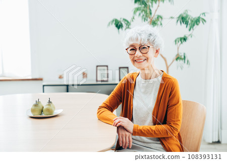 Senior woman relaxing in the dining room 108393131