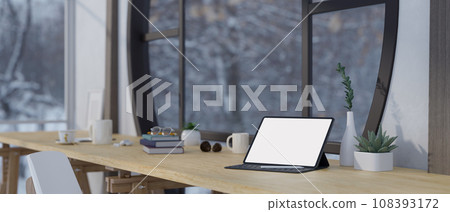 A white-screen tablet mockup with a wireless keyboard and stationery on a desk in a modern room. 108393172