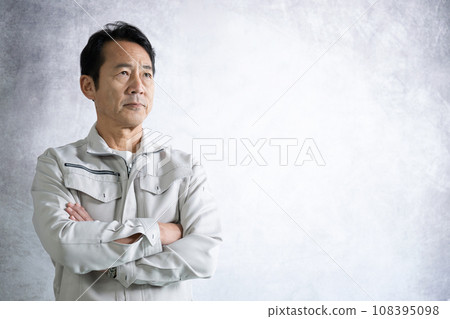 Middle-aged man in work clothes, upper body close-up, arms crossed, looking at camera 108395098