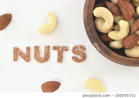 An overhead view of unglazed mixed nuts on a wooden plate An overhead view of unglazed mixed nuts on a wooden plate 108395552