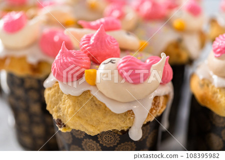 Freshly baked mini Easter bread kulich with lemon glaze, decorated with sprinkles and meringue bird-shaped cookies. Freshly baked mini Easter bread kulich with lemon glaze, decorated with sprinkles and meringue bird-shaped cookies. 108395982