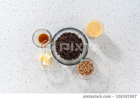 Flat lay. Measured ingredients in glass mixing bowls to make chocolate fudge with peanut butter swirl. Flat lay. Measured ingredients in glass mixing bowls to make chocolate fudge with peanut butter swirl. 108395987