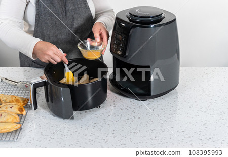 Frying sweet cherry empanadas in the air fryer. 108395993