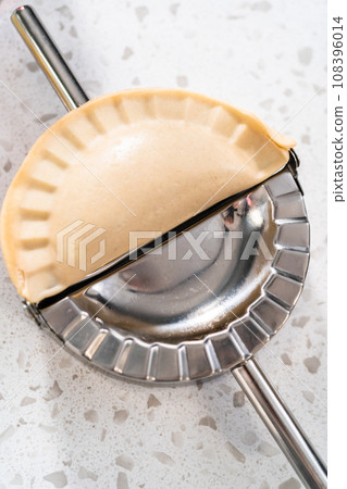 Filling empanada dough with cherry pie filling to make sweet cherry empanadas in the air fryer. 108396014