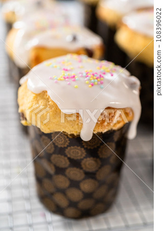 Glazing mini Easter bread kulich with a white lemon glaze. 108396022