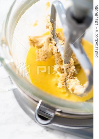 Mixing ingredients in kitchen mixer to bake mini Easter bread kulich. Mixing ingredients in kitchen mixer to bake mini Easter bread kulich. 108396086