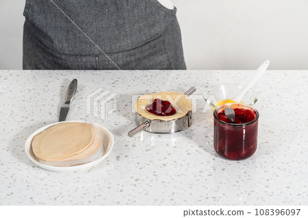 Filling empanada dough with cherry pie filling to make sweet cherry empanadas in the air fryer. Filling empanada dough with cherry pie filling to make sweet cherry empanadas in the air fryer. 108396097