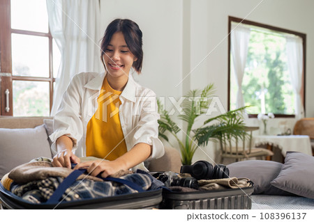 Young woman sit in floor and preparation suitcase for travelling at weekend trip 108396137