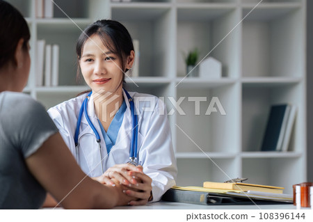 doctor therapist wearing white uniform with stethoscope touching frustrated patient hands doctor therapist wearing white uniform with stethoscope touching frustrated patient hands 108396144