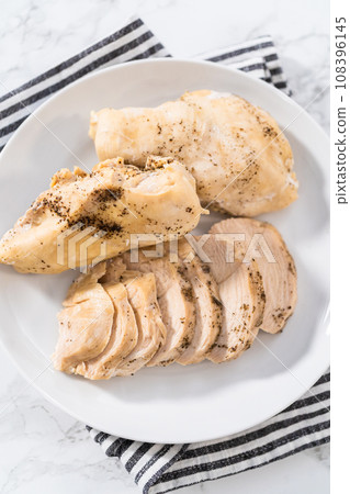 Shredded chicken in a pressure cooker. Freshly cooked chicken breasts on a white plate. Shredded chicken in a pressure cooker. Freshly cooked chicken breasts on a white plate. 108396145