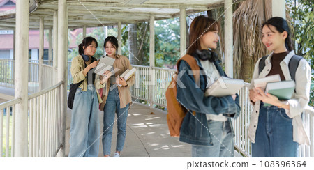 university students using a digital tablet while walking to next class 108396364