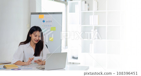 Businesswoman using a calculator to calculate numbers on a company's financial documents, she is analyzing historical financial data to plan how to grow the company. Financial concept 108396451