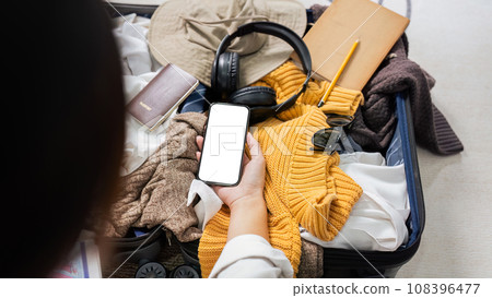Mockup mobile phone with white screen, luggage in background 108396477