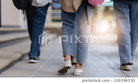 university students using a digital tablet while walking to next class university students using a digital tablet while walking to next class 108396530