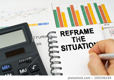 There is a calculator on the table, business charts, a man made a note in a notebook - REFRAME THE SITUATION 108398284