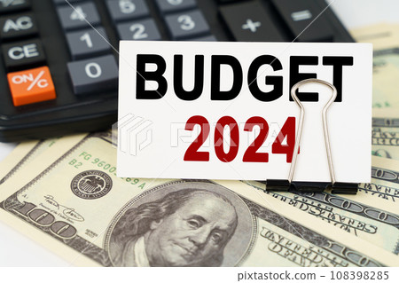 On the dollars there is a calculator and a business card with the inscription - BUDGET 2024 108398285