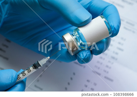 doctor's hand holds a syringe and a blue vaccine bottle at the hospital. Health and medical concepts. 108398666
