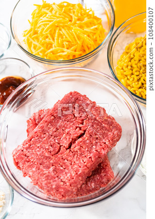 Measured ingredients in glass mixing bowls to make homemade hamburger helper. 108400107