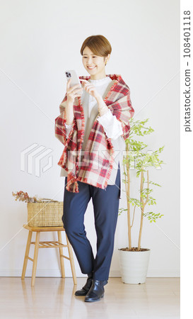 Full body of a woman using a smartphone (vertical orientation) 108401118