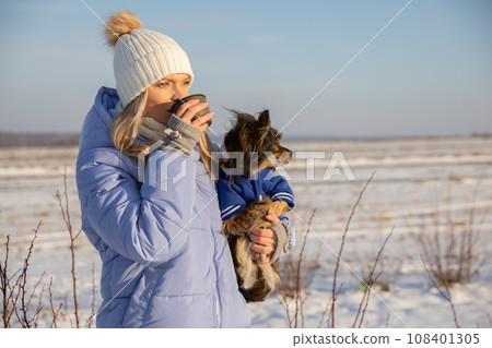 The dog and its owner visible against the winter landscape. 108401305