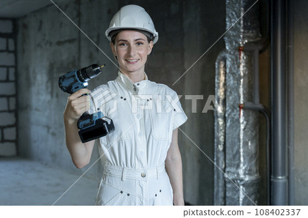 Young girl dressed for repairs is standing and holding a screwdriver in her hand. Tools for girls and men Young girl dressed for repairs is standing and holding a screwdriver in her hand. Tools for girls and men 108402337