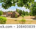 Small cozy houses. Wooden ancient buildings. Summer village and vacation. Farm bio products. 108403839