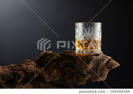 Glass of whiskey on a old snag. 108404304
