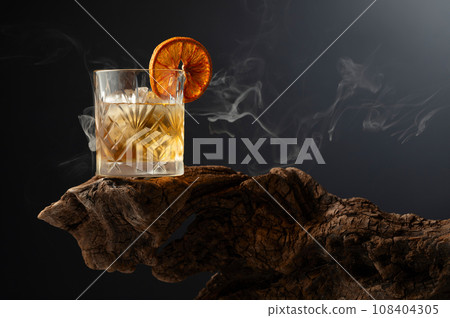 Smoked old fashioned cocktail with ice and dried orange slice. Smoked old fashioned cocktail with ice and dried orange slice. 108404305
