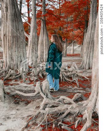 Attractive woman in a jacket in autumnal park. Portrait of people in park in autumn. Attractive woman in a jacket in autumnal park. Portrait of people in park in autumn. 108405424