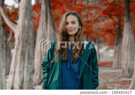 Portrait of attractive woman walking down the park and looking at the camera. Portrait of attractive woman walking down the park and looking at the camera. 108405427