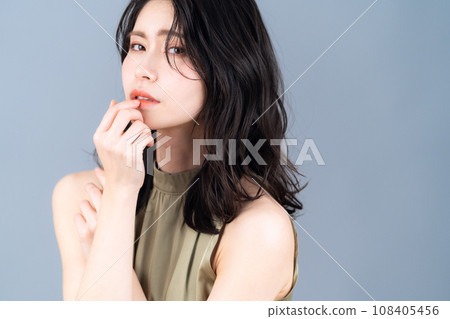 A middle-aged woman doing skin care against a gray background A middle-aged woman doing skin care against a gray background 108405456