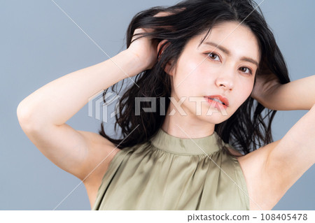 A middle-aged woman doing skin care against a gray background A middle-aged woman doing skin care against a gray background 108405478